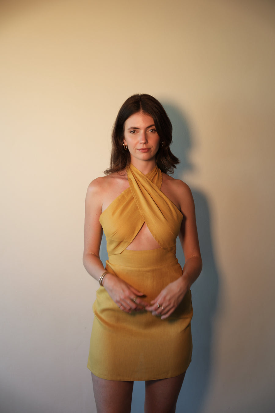 Woman wearing a yellow dress against a plain background